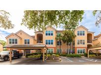 Front view of a two-story condo building with parking and landscaping at 4142 Central Sarasota Pkwy # 1428, Sarasota, FL 34238