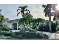 Single-story home with tile roof, palm trees, and landscaped yard at 479 Summerfield Way, Venice, FL 34292