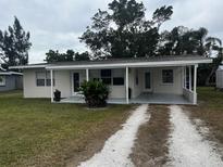 Ranch-style home with covered porch and spacious yard at 5938 S Lockwood Ridge Rd, Sarasota, FL 34231