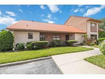 Exterior of a Spanish-style condo with a tiled roof, landscaping, and walkway at 6542 Draw Ln # 90, Sarasota, FL 34238