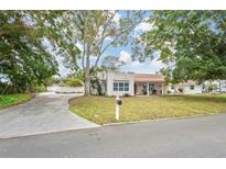 Single-story home with a terracotta roof, driveway, and mature landscaping at 7705 Alhambra Dr, Bradenton, FL 34209