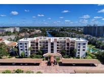 Aerial view of a condo building with parking and a pool at 1100 Cove Ii Pl # 910, Sarasota, FL 34242