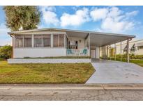 Single-wide manufactured home with carport and covered porch at 1523 46Th E Ave, Ellenton, FL 34222