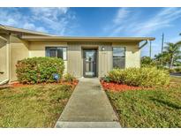 Front view of a light beige house with gray accents, landscaped lawn, and walkway at 2709 60Th Avenue N Plz # D, Bradenton, FL 34207