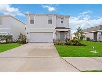 Two-story house with gray siding, stone accents, and a two-car garage at 3408 Hilltop Cir, Bradenton, FL 34211