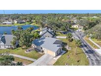 Aerial view of a single-Gathering home with a lake and lush landscaping at 5384 Sarapointe Ct, Sarasota, FL 34232