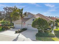 Single-story home with three-car garage, and manicured landscaping at 7070 Woodmore Ter, Lakewood Ranch, FL 34202