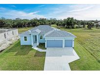 New construction home with a three-car garage and spacious lawn at 75 Mark Twain Ln, Rotonda West, FL 33947