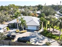 Single-Gathering home with a large driveway, two cars, and lush landscaping at 3011 Ashton Rd, Sarasota, FL 34231