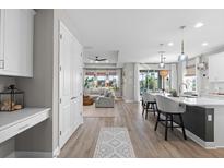 Open concept kitchen with white cabinets and an island that overlooks the living room at 1021 Fernleaf Run, Bradenton, FL 34212