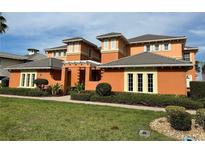 Luxury three-story home with orange exterior, landscaping, and walkway at 1139 Riverscape St # 2D, Bradenton, FL 34208