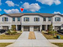Modern townhome exterior with two-car garage and landscaping at 14350 Easy Goer St, Ruskin, FL 33573