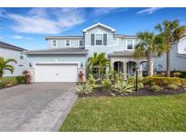 Two-story home with light blue exterior, stone accents, and landscaped yard at 3431 Chestertown Loop, Bradenton, FL 34211