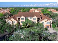 Aerial view of a two-story building with brown roof and lush green surroundings at 4152 Central Sarasota Pkwy # 727, Sarasota, FL 34238