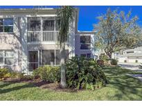 Condo building with lush landscaping and screened balconies at 5697 Sheffield Greene Cir # 51, Sarasota, FL 34235