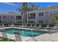 Community pool with ample lounge chairs and patio tables at 5697 Sheffield Greene Cir # 51, Sarasota, FL 34235