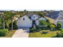 White house with gray roof, two-car garage, and lush landscaping at 11422 Griffith Park Ter, Bradenton, FL 34211