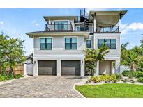 Three-story house with two-car garage, spiral staircase, and landscaped yard at 171 Mckinley Dr, Sarasota, FL 34236