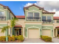 Green two-story townhome with two-car garage and landscaping at 204 Crew Ct, Sarasota, FL 34243