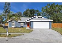 Updated home exterior boasts a blue facade, white garage door, and landscaped lawn at 3511 65Th Avenue E Cir, Sarasota, FL 34243
