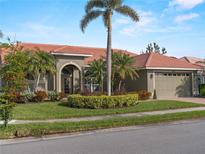 Single-story home with tile roof, palm trees, and landscaped yard at 4472 Via Del Villetti Dr, Venice, FL 34293