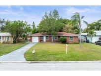Brick ranch house with a spacious yard and driveway at 102 N Mars Ave, Clearwater, FL 33755