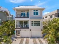 Two-story house featuring a modern design, two-car garage, and a metal roof at 106 9Th S St, Bradenton Beach, FL 34217