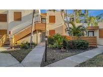 Exterior view of condo building showcasing landscaping and walkway at 144 Wild Palm Dr, Bradenton, FL 34210