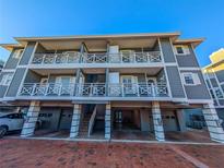 Three-story building with gray siding, balconies, and parking at 1552 Stickney Point Rd # 403, Sarasota, FL 34231