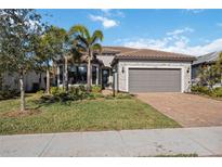 Single-story home with gray siding, tile roof, and a two-car garage at 17530 Northwood Pl, Bradenton, FL 34202