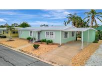 Charming light green manufactured home with carport and landscaped yard at 2107 Palma Sola Blvd # 82, Bradenton, FL 34209