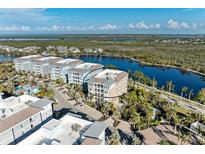 Aerial view of waterfront condo building with parking and landscaping at 395 Aruba Cir # 302, Bradenton, FL 34209