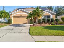 Tan house with solar panels, palm trees, and a well-manicured lawn at 4440 Sanibel Way, Bradenton, FL 34203