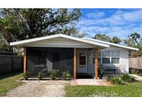 Charming one-story home with a screened porch and well-manicured landscaping at 980 Charlotte Ave, Sarasota, FL 34237