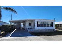White mobile home with carport, landscaping, and storage shed at 10315 Cortez W Rd # 37F, Bradenton, FL 34210