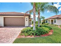 Attractive single-story home with a brown garage door and landscaped front yard at 12651 Garibaldi Ln, Venice, FL 34293