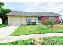 Brick ranch home with attached garage and well-maintained lawn at 13457 Muriel Ave, Port Charlotte, FL 33981