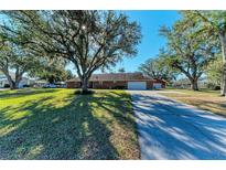Brick ranch home with large yard, mature trees, and long driveway at 6300 26Th E Ave, Bradenton, FL 34208