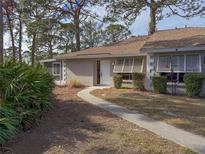 Tan house exterior with walkway, landscaping, and screened porch at 727 N Jefferson Ave # 727, Sarasota, FL 34237