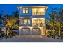Two-story home with a modern design, two-car garage, and palm trees at 105 6Th S St, Bradenton Beach, FL 34217