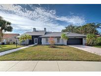 Single-story home with gray exterior, tile roof, and landscaped yard at 1051 Truman St, Nokomis, FL 34275