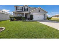 Two-story house with gray siding, landscaping, and a two-car garage at 15404 Trinity Fall Way, Bradenton, FL 34212