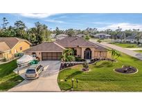 Attractive single-Gathering home with a well-manicured lawn and a two-car garage at 23039 Worth Ave, Port Charlotte, FL 33954