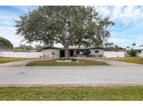 Ranch style home with mature landscaping and a large driveway at 2430 Sunnyside Ln, Sarasota, FL 34239