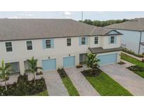 Modern townhome community with light-colored exteriors and attached garages at 5447 Tripoli Dr, Palmetto, FL 34221