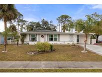 White single story home with palm trees and well manicured lawn at 8142 Coco Solo Ave, North Port, FL 34287
