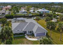 Aerial view of canal-front home with pool and lush landscaping at 9008 Allapata Ln, Venice, FL 34293