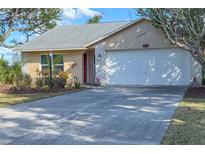 Tan house with white garage door and red front door at 1204 W 20Th Ave, Palmetto, FL 34221