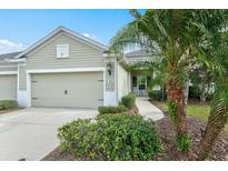 Front view of charming house with attached garage and landscaped yard at 3922 Wildgrass Pl, Parrish, FL 34219