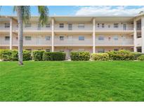 Condo building with lush landscaping and a manicured lawn at 3987 Maceachen Blvd # 123, Sarasota, FL 34233